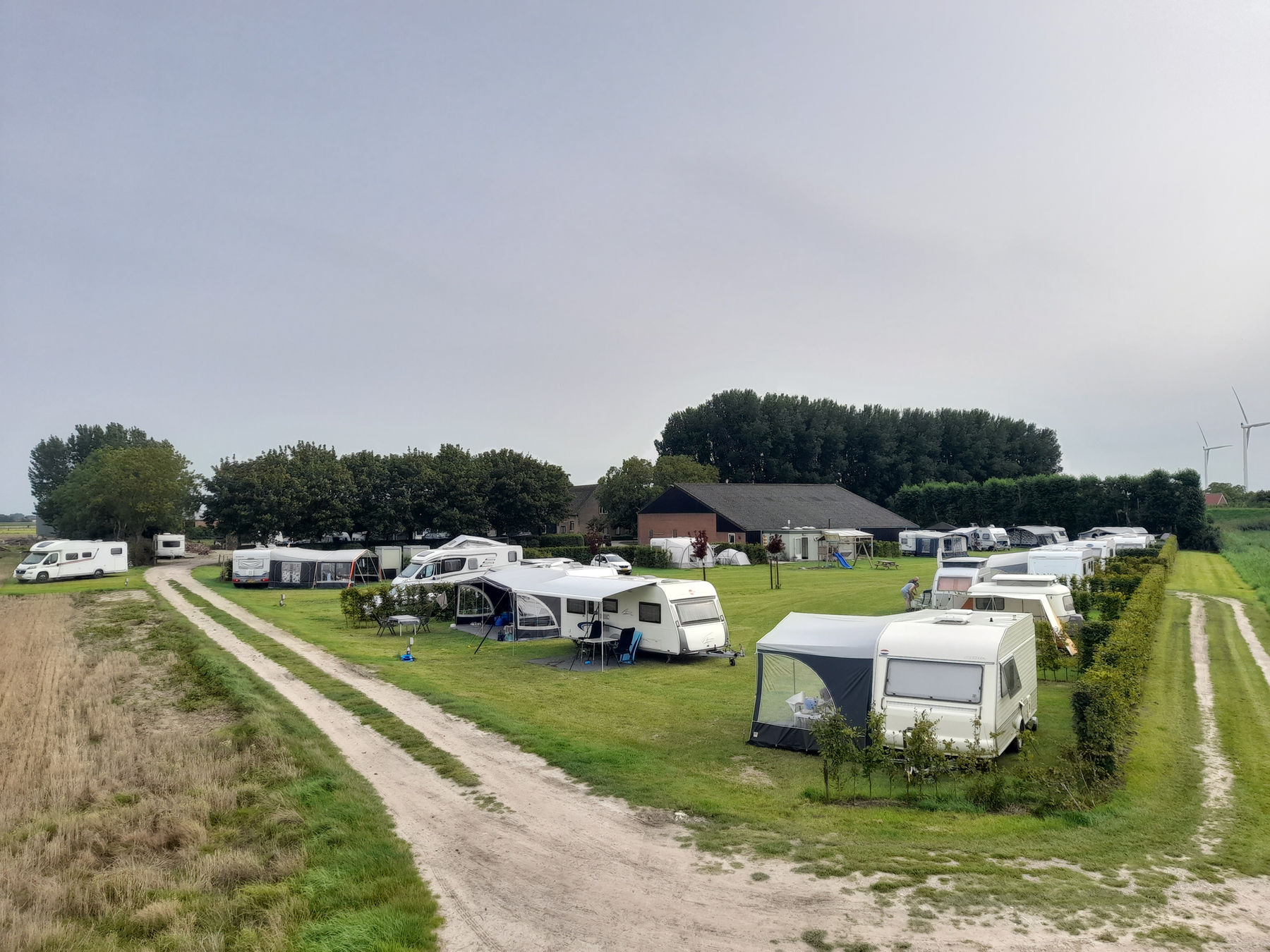 Gasten op de kampeerweide van Mariëndreef in de avondzon